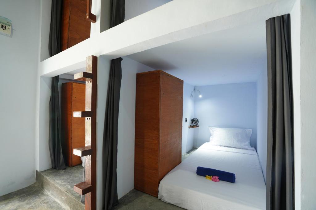 龙目岛库塔Waiwas Hostel的一间小卧室,配有一张床和一个楼梯