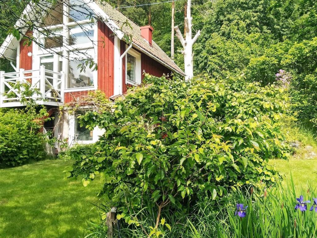 Floda5 person holiday home in FLODA的院子里有大灌木的房子