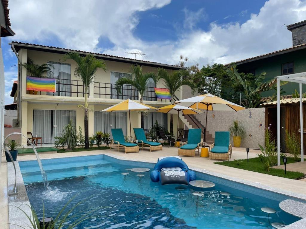 萨尔瓦多Pousada Villa Encantada LGBTQIAPlus的游泳池,带椅子和遮阳伞