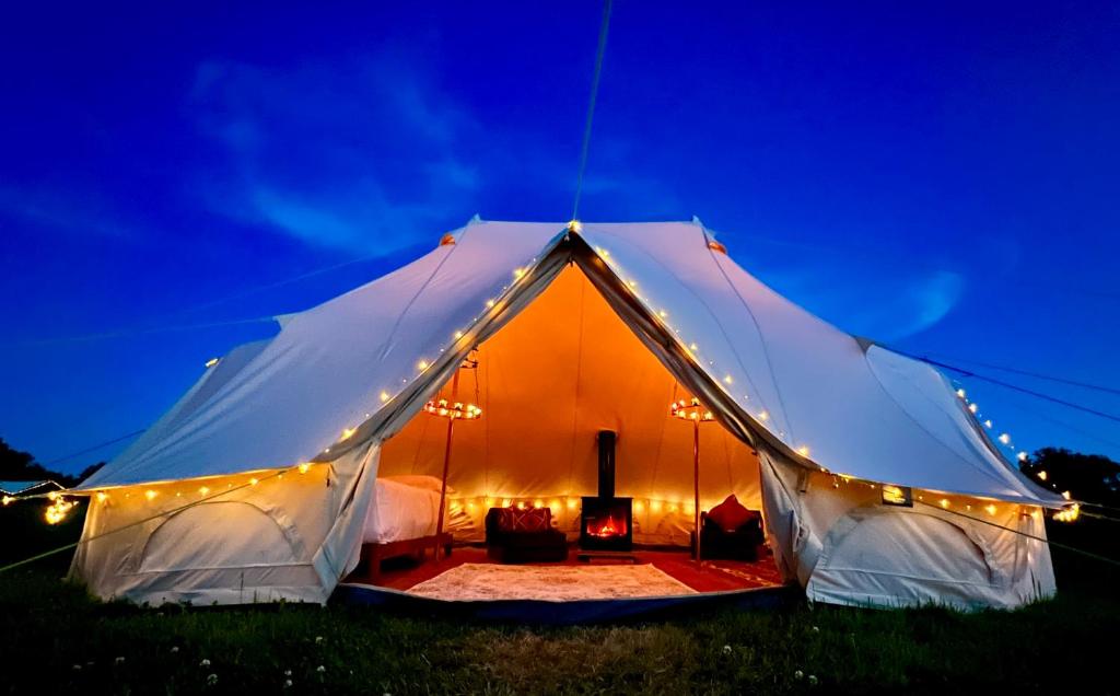 霍尼顿Hartridge Springs的夜晚在田野里带灯的白色帐篷