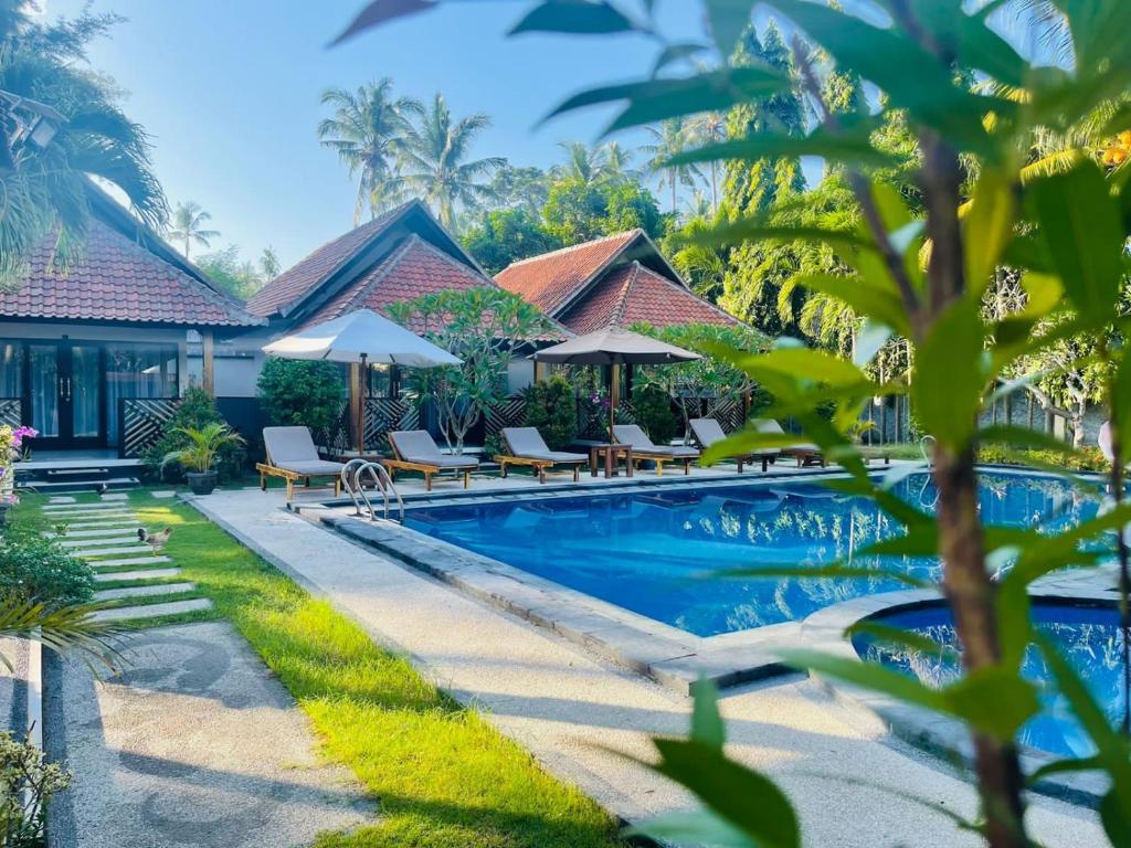 甘地达萨巴厘岛慕蒂亚拉酒店的一个带椅子和遮阳伞的度假游泳池
