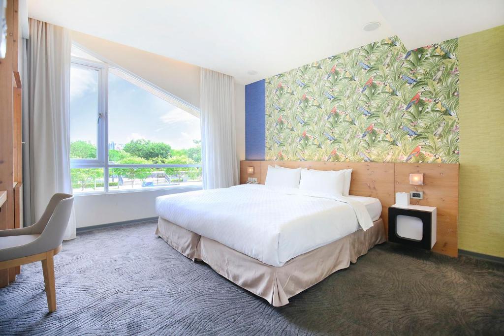 台北丹迪旅店大安森林公园店的酒店客房设有一张床和一个大窗户