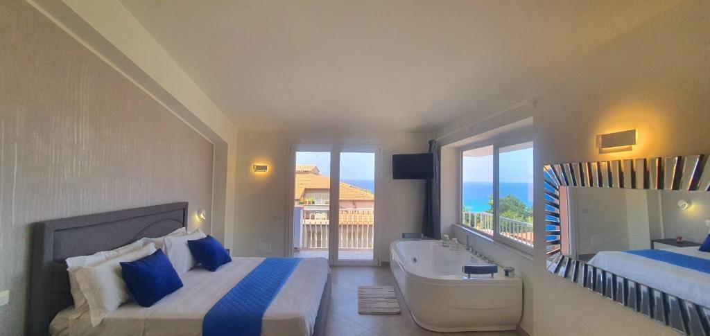 特罗佩阿Imperial Rooms Tropea的一间卧室设有两张床、一个浴缸和一个窗口。