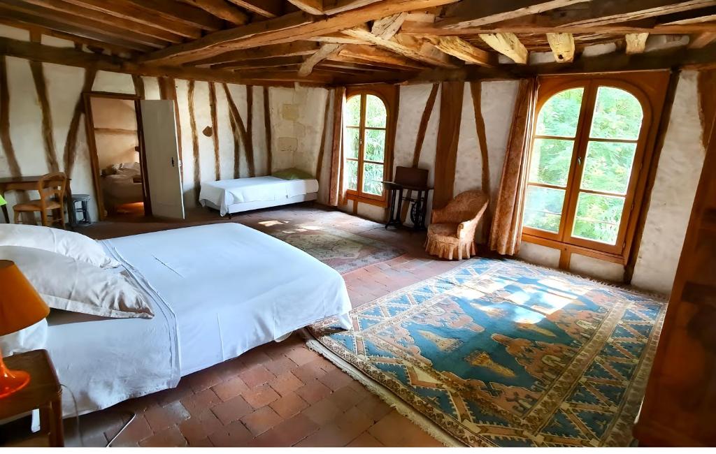 阿姆博斯Aux Ecuries du Signe的一间设有床铺的卧室,位于带窗户的房间内