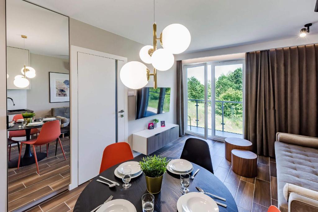科沃布热格VacationClub – Porta Mare Baltica Apartament 8A的用餐室以及带桌椅的起居室。