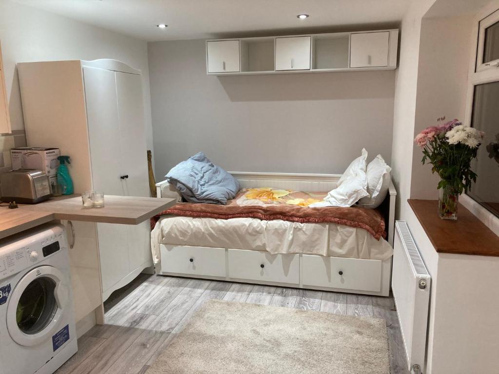 Golders GreenLondon retreat的小房间设有床铺和洗衣机