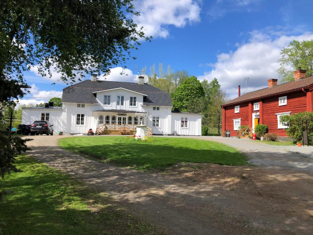 海勒福什Bredsjö Gamla Herrgård White Dream Mansion的一座大型白色房子,设有红色谷仓