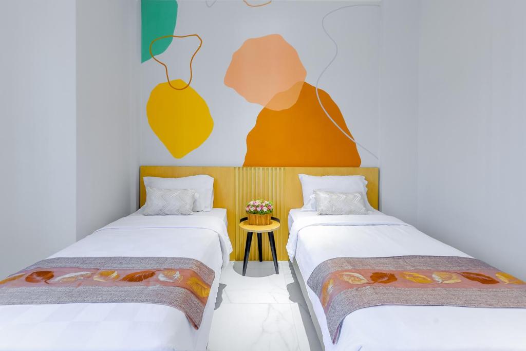 美娜多Genio Inn - MANTOS的一间设有两张床和一张桌子的房间