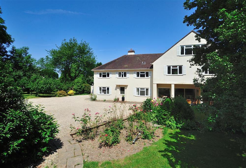 RousdonThe Orchard Country House的一座白色的大房子,前面设有一个花园