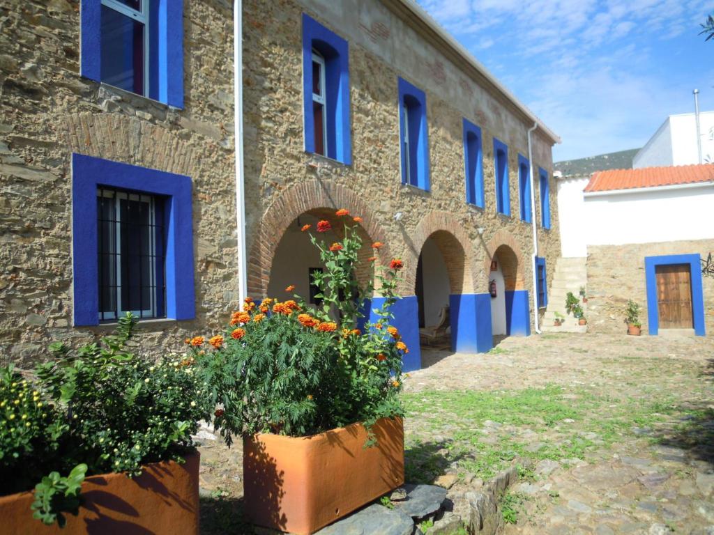 Cañaveral卡纳维拉尔旅舍的建筑前方有蓝色的窗户和鲜花