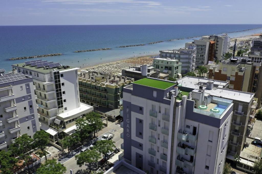 佩萨罗Amadei Hotel Figaro & Apartments的享有城市的顶部景色,拥有海滩和建筑