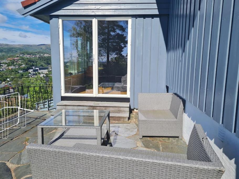 卑尔根Beautiful Villa with amazing view in Bergen.的一个带玻璃桌和椅子的庭院