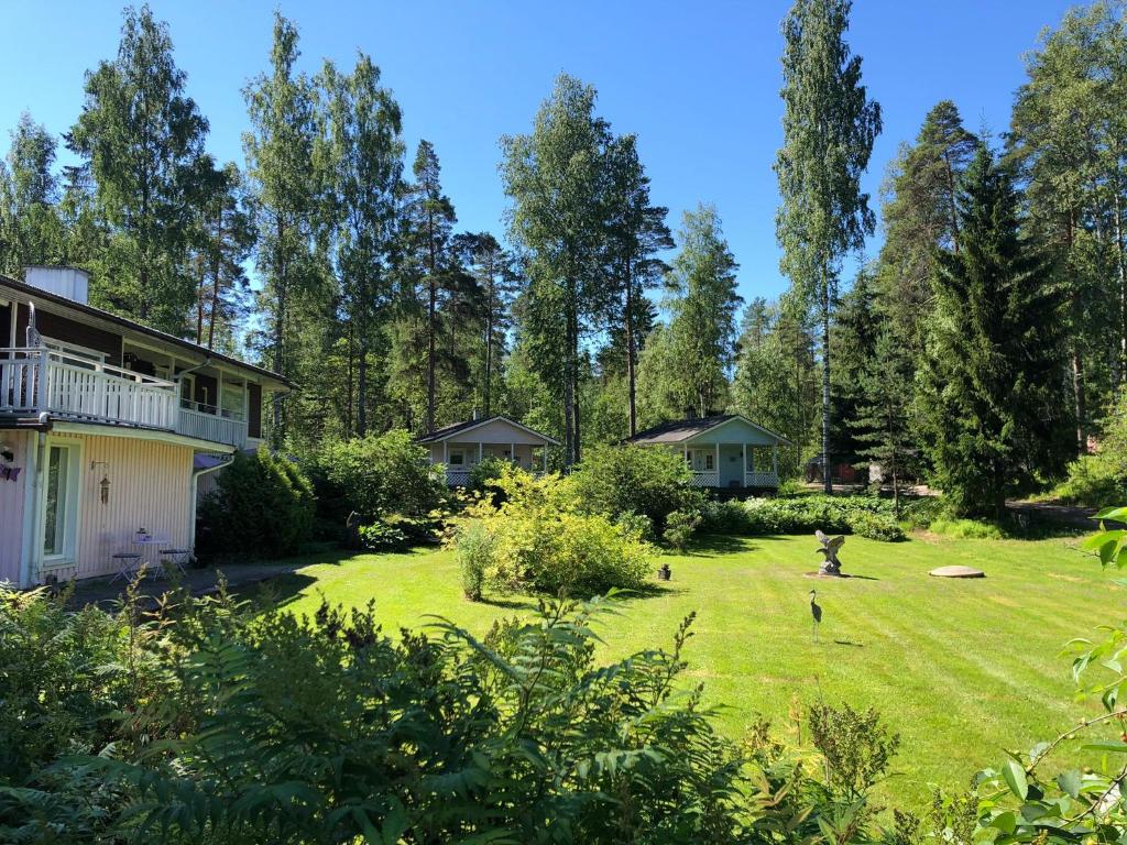 SöderkullaJuhlamenot Oy的享有带房屋和树木的庭院的景色