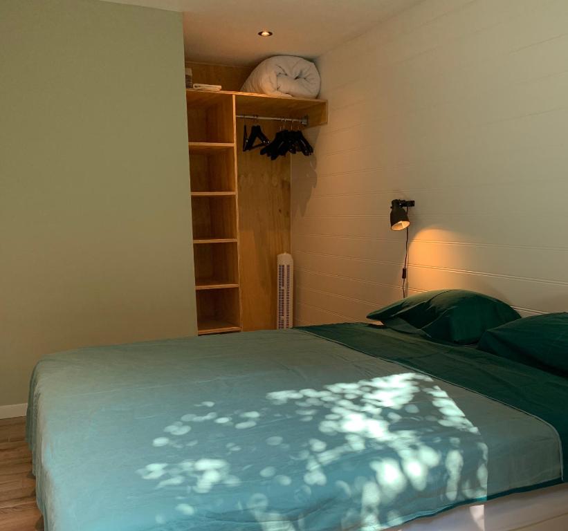 斯海弗宁恩Tinyhouse Scheveningen beach FREE gated parking的一间卧室配有一张带绿毯的床