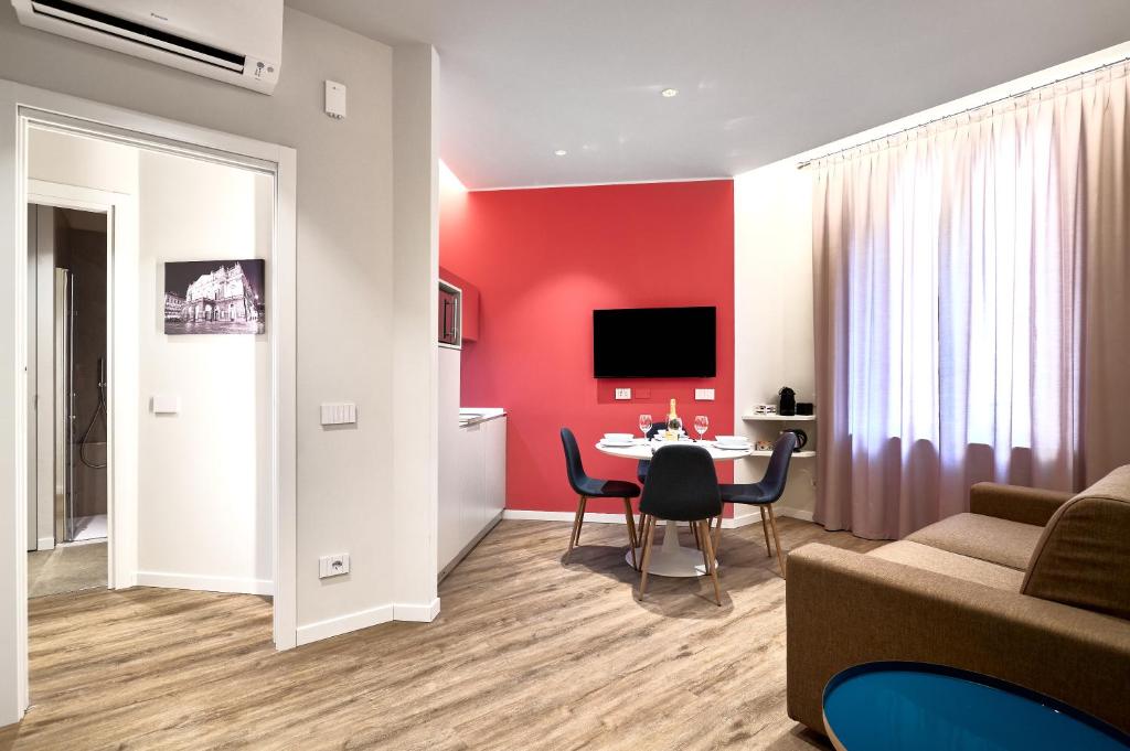 米兰DONATELLO11 Milan apartments的客厅设有桌子和红色的墙壁