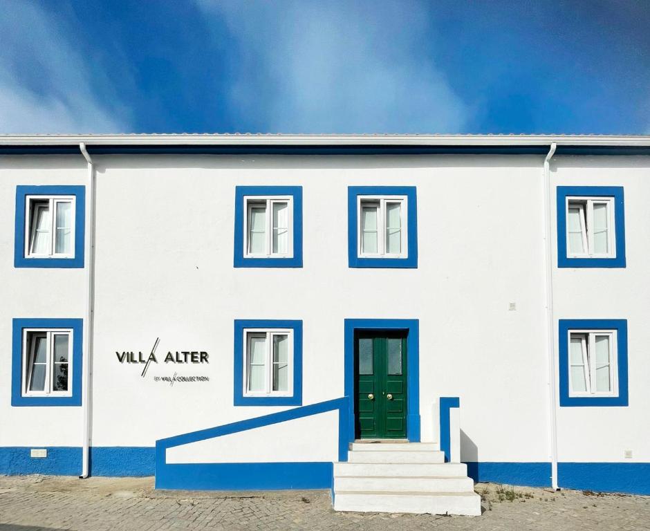 阿尔特杜尚Villa Alter的白色的建筑,有蓝色的修饰和绿色的门