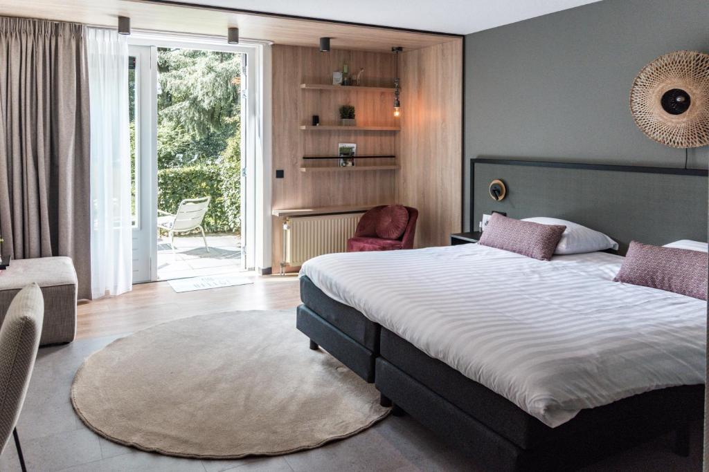 伊皮Witte Berken Natuurhotel的一间卧室配有一张大床和一把椅子