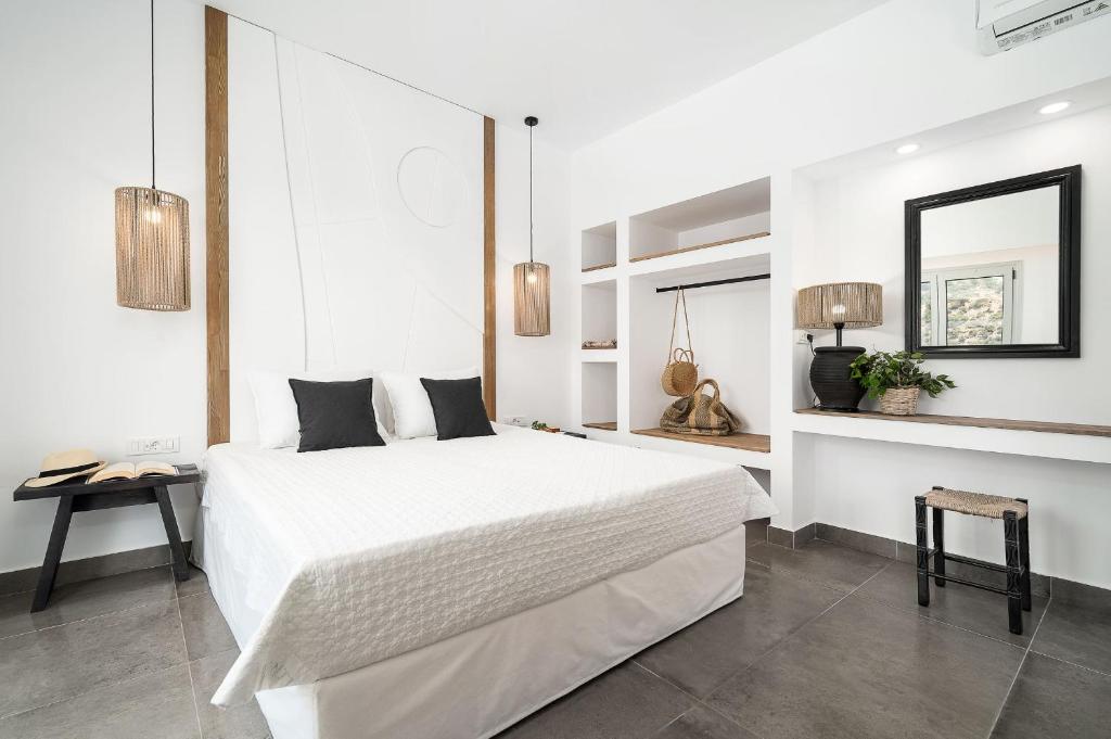 圣加利尼Stella Luxury Apartments的白色卧室设有一张大床和镜子