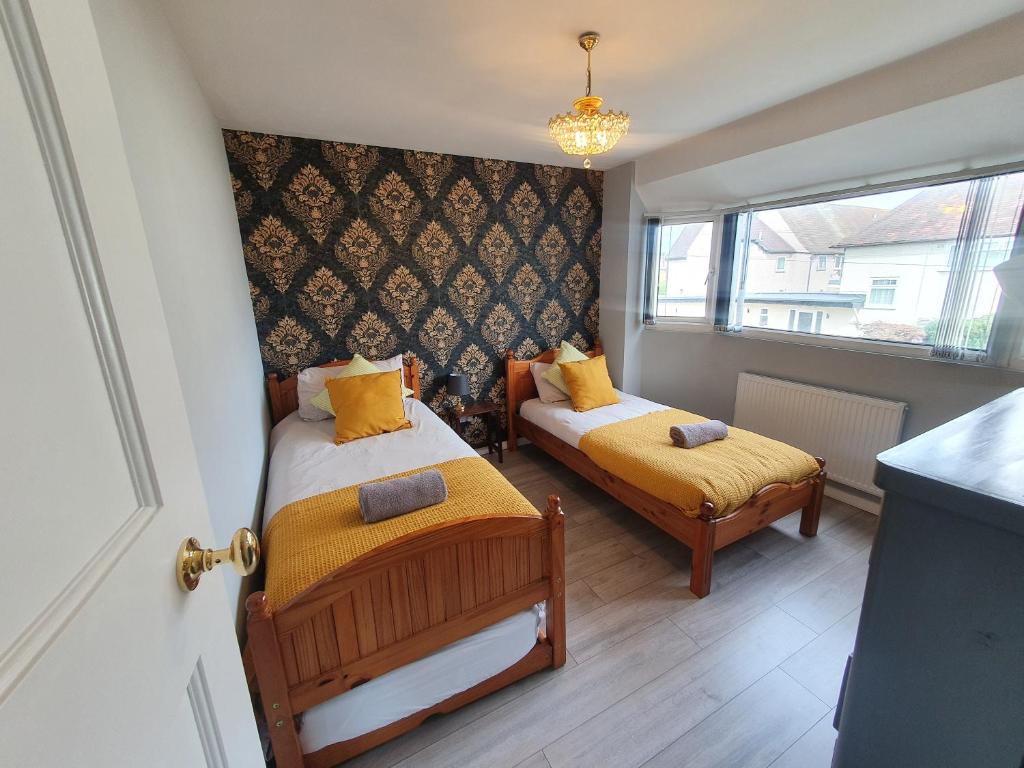 斯劳Luxury Victorian Home Slough, Legoland, Windsor的一间小卧室,配有两张床和窗户