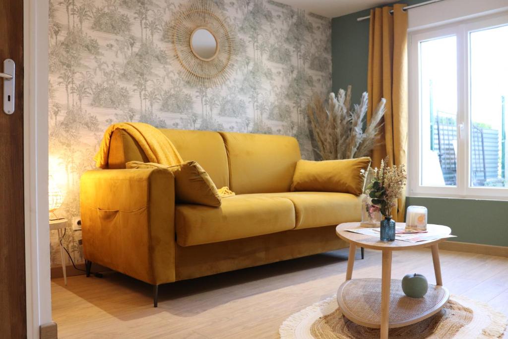 沙勒维尔-梅济耶尔Le Bohème的客厅里一张黄色的沙发,配有桌子