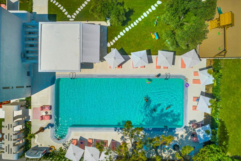 弗尔卡Cocoοns Luxury Suites & Villas的享有带遮阳伞的游泳池的顶部景致