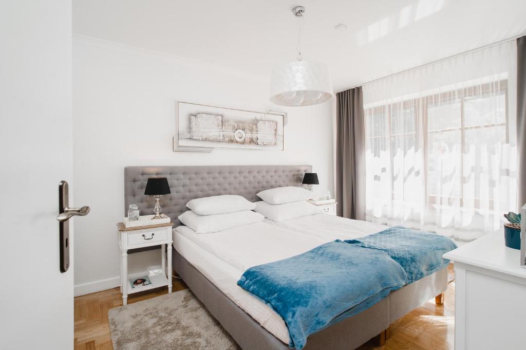 库瑞尼卡慕斯卡Apartament Marta Luxury的白色的卧室设有一张大床和一个窗户