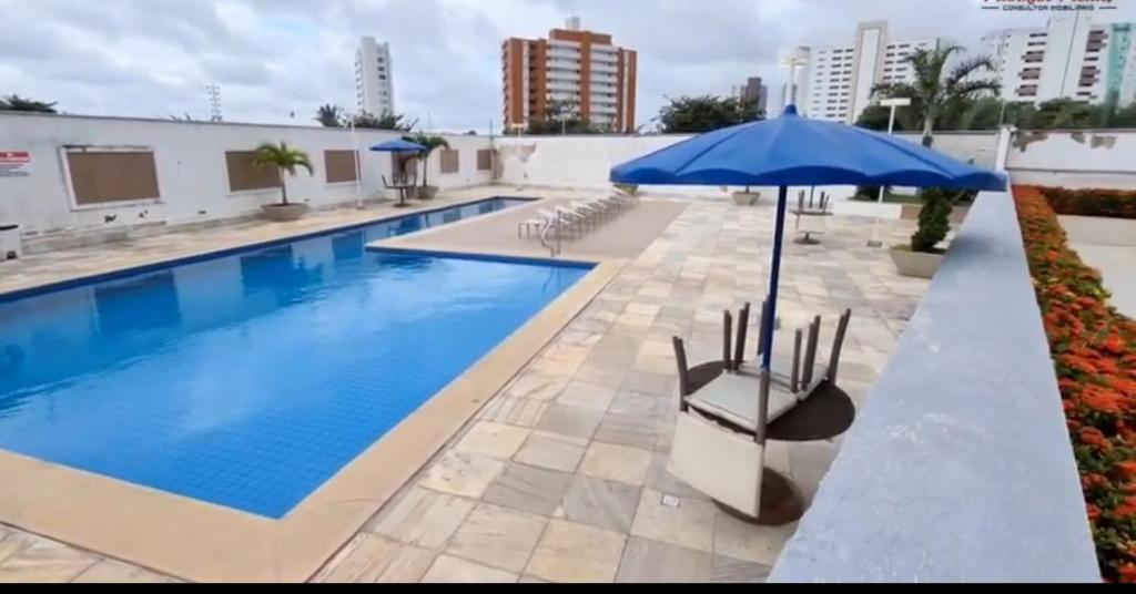 圣路易斯APARTAMENTO LUXUOSO A 1KM DA LITORÂNEA的一个带遮阳伞和椅子的大型游泳池