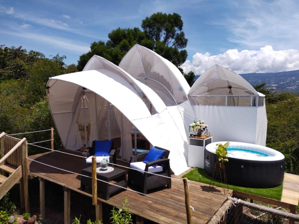莱瓦镇Origen Glamping en Villa de Leyva的一个带热水浴缸和两个帐篷的豪华蒙古包