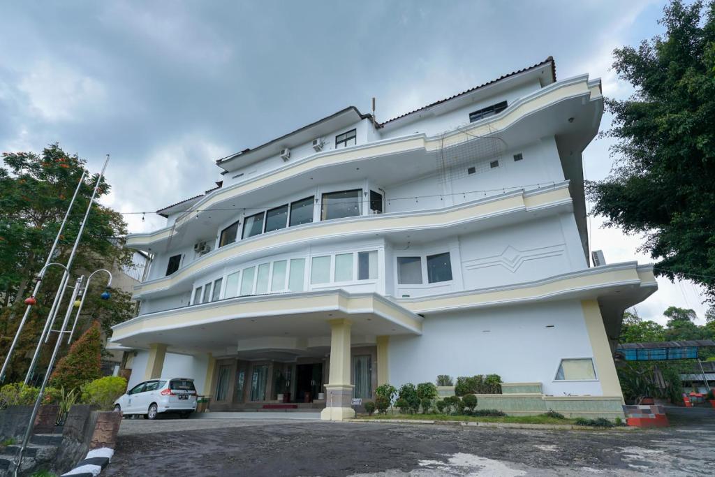 KebintiUrbanview Hotel Pangkalpinang by RedDoorz的前面有一辆汽车停放的白色建筑
