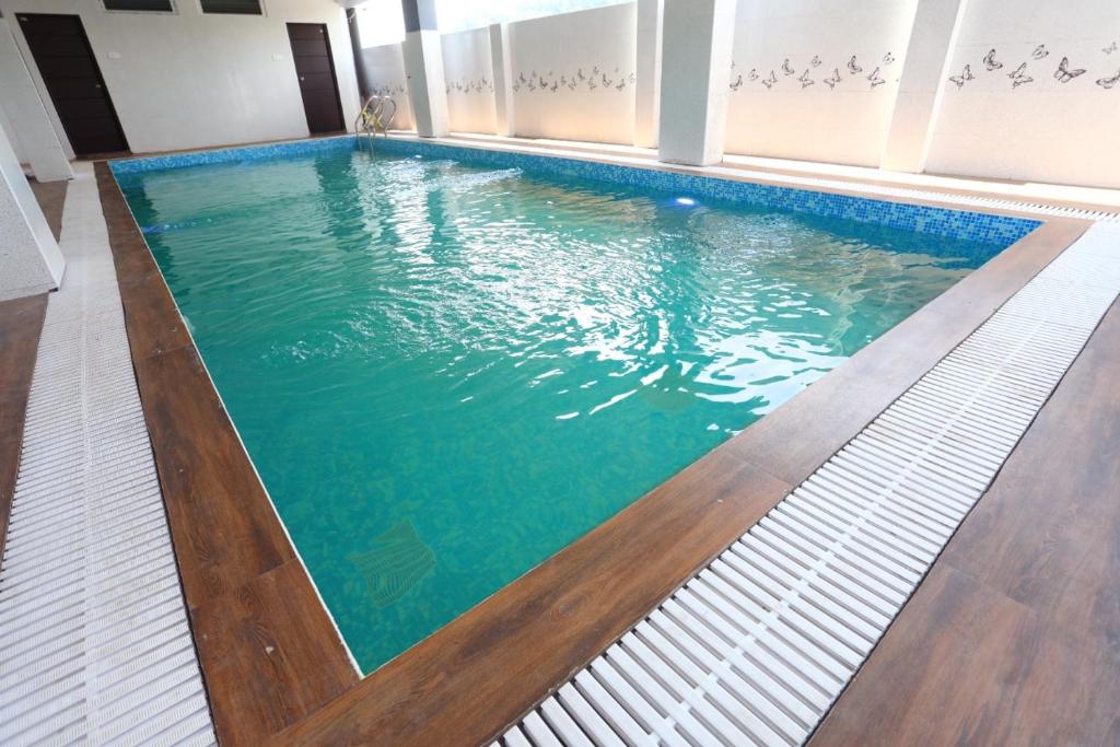 埃尔加德Le cressida Hotel的铺有木地板并拥有蓝色海水的游泳池