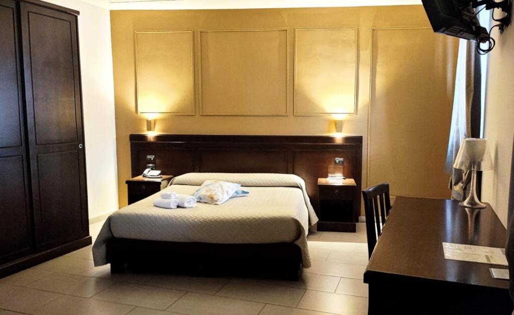 雷焦卡拉布里亚阿尔巴努欧瓦酒店的一间卧室配有一张床、一张桌子和一张书桌