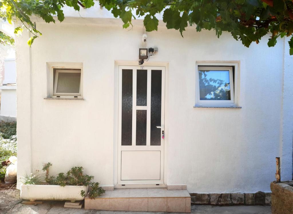 洛帕Apartmani Ana-Lora的白色的房子,有白色的门和窗户