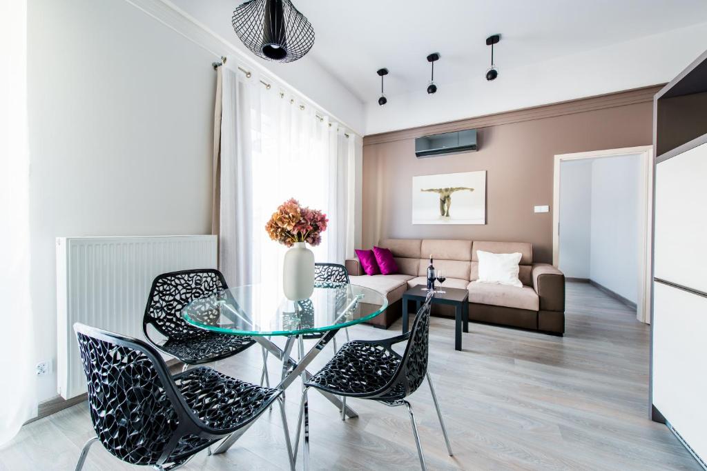 比亚韦斯托克中心高级套房公寓的客厅配有玻璃桌和椅子