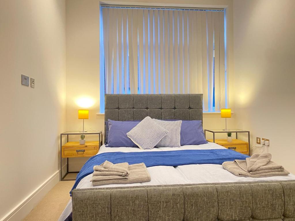 卢顿10080 Luxury Apartment near Luton town Mall的一间卧室配有一张大床和毛巾