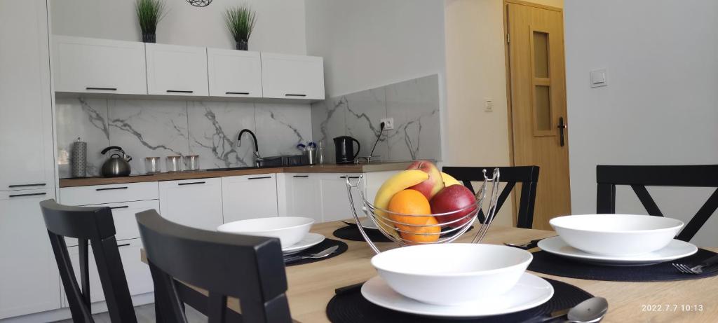 塔尔努夫Apartament Magnolia -centrum的厨房配有带一碗水果的桌子