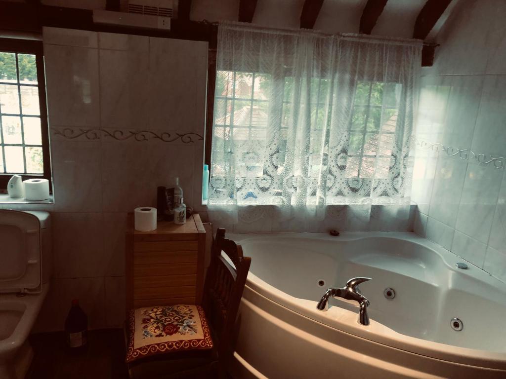 Goffs OakTudor House - Double Room - Shared Bathroom的带浴缸、窗户和水槽的浴室