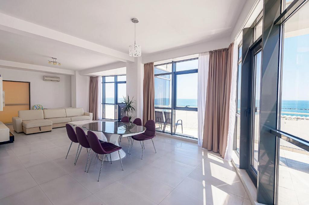 马马亚海滨住宅公寓酒店的客厅配有玻璃桌和椅子