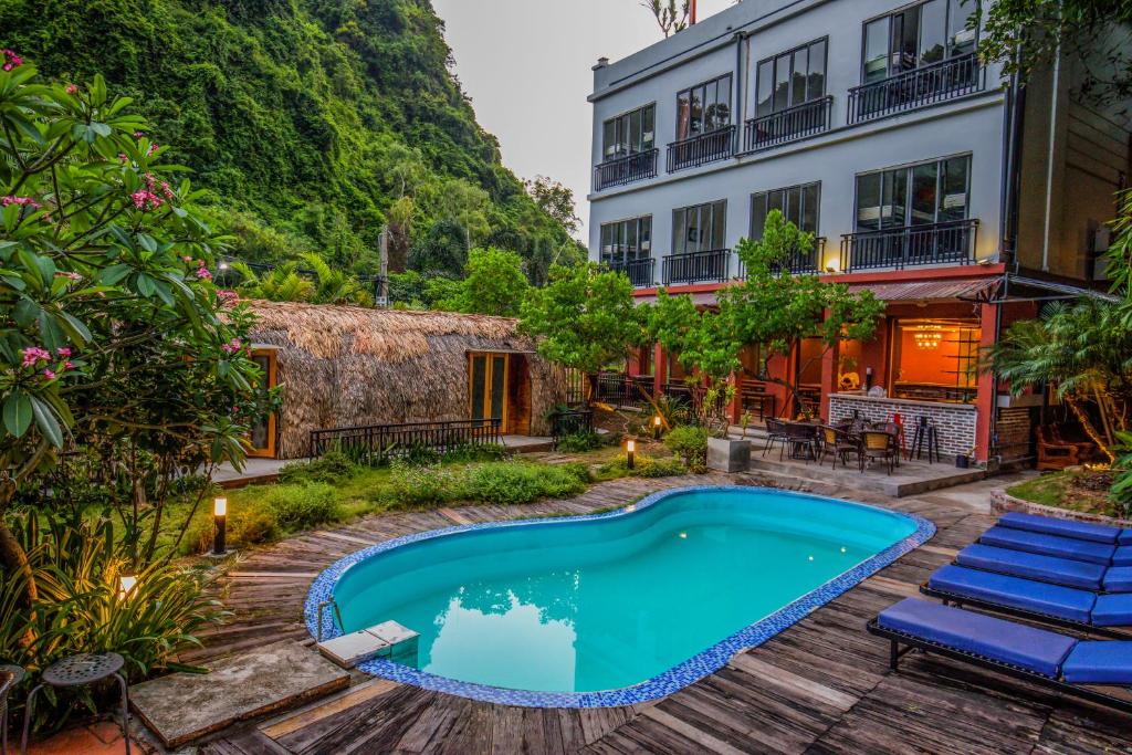 吉婆岛Catba Backpackers Hostel & Pool Bar的一座游泳池,位于一座建筑旁的院子内