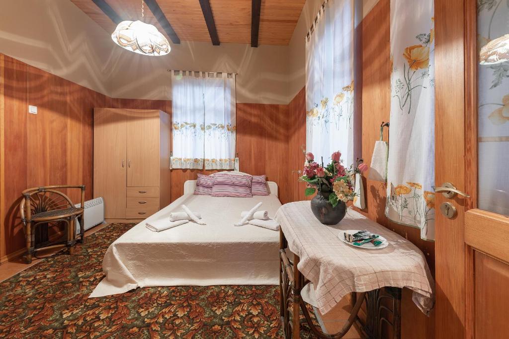 尤尔马拉Valensija - Cute cottage in big yard的一间卧室配有一张床和一张鲜花桌子