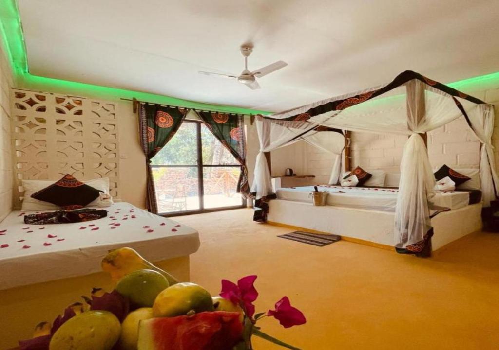 肯杜瓦Tropicana Garden的客房设有带两张床的卧室和一张带水果的桌子。