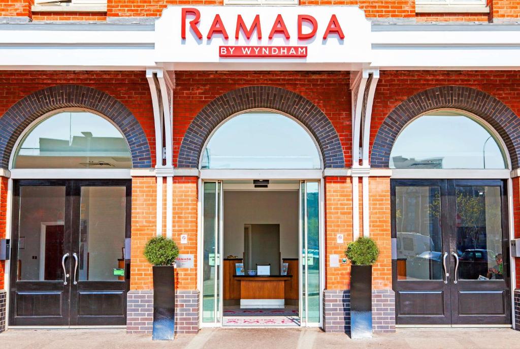 贝尔法斯特Ramada by Wyndham Belfast的红砖建筑,有三扇拱形门