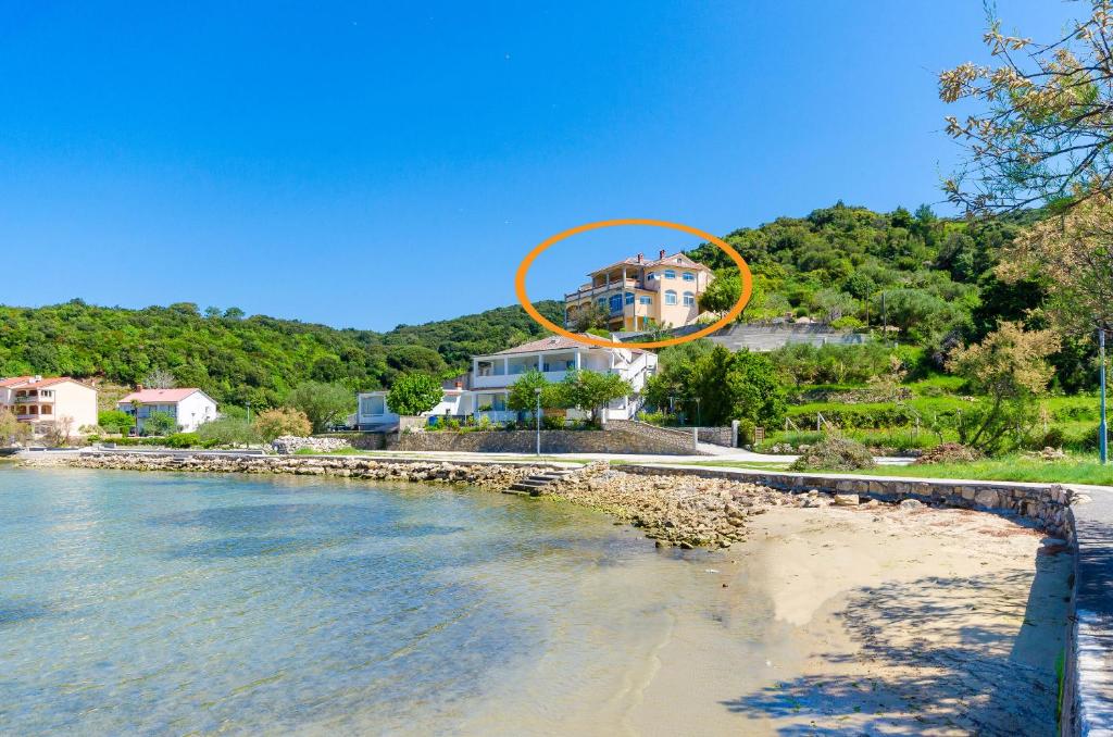 苏佩塔斯卡德拉加Apartments Katica的海滩上有一个橙色圆圈的房子