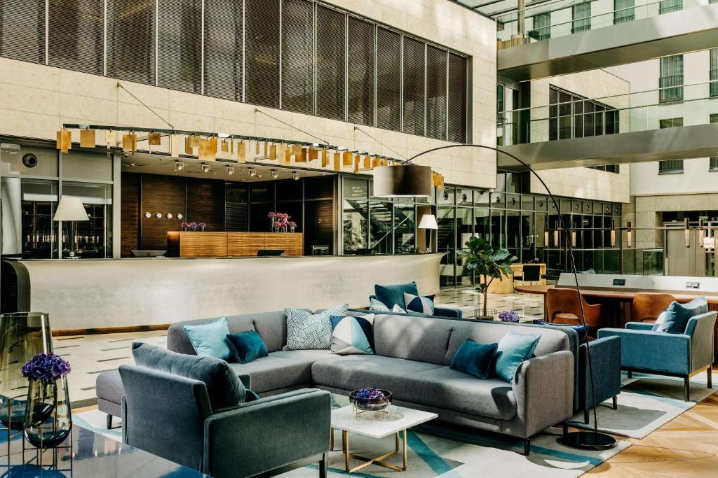 杜塞尔多夫Hotel Kö59 Düsseldorf - Member of Hommage Luxury Hotels Collection的大楼内一个带沙发和椅子的大堂