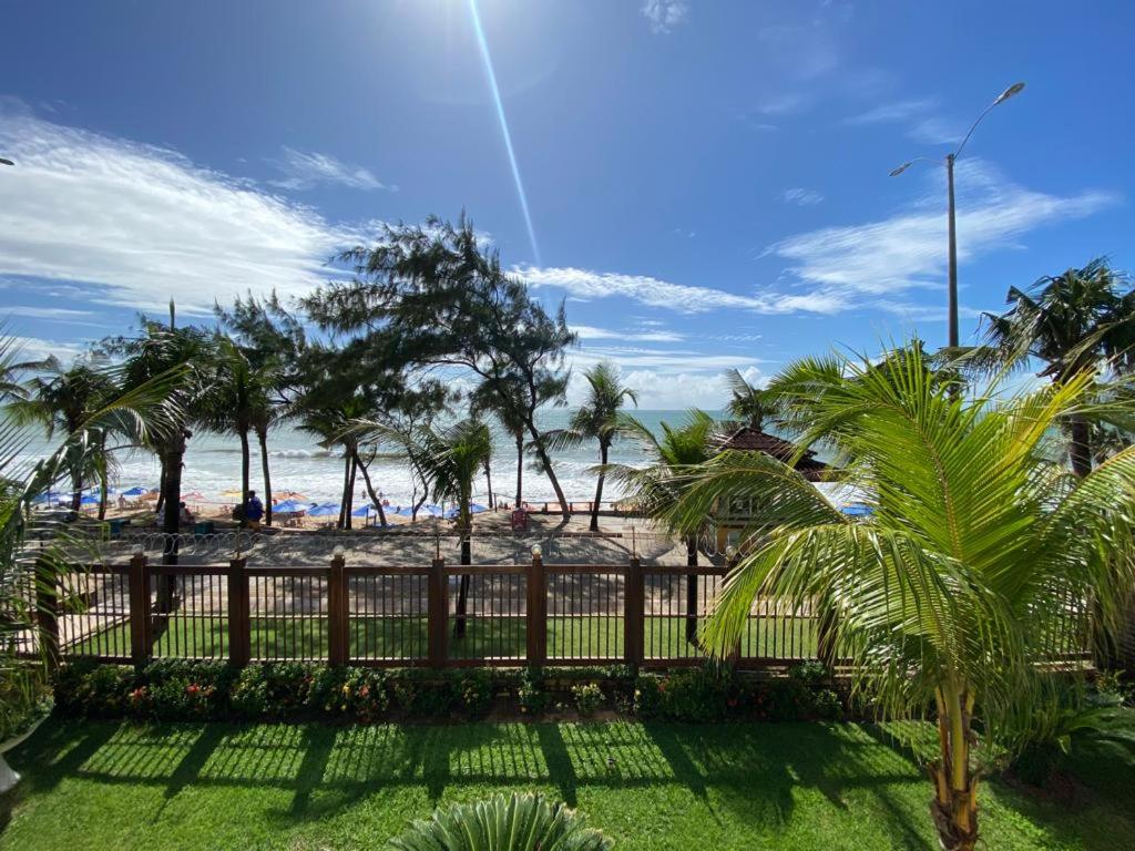 纳塔尔Araçá Praia Flat - Ponta Negra的享有棕榈树海滩和围栏的景色