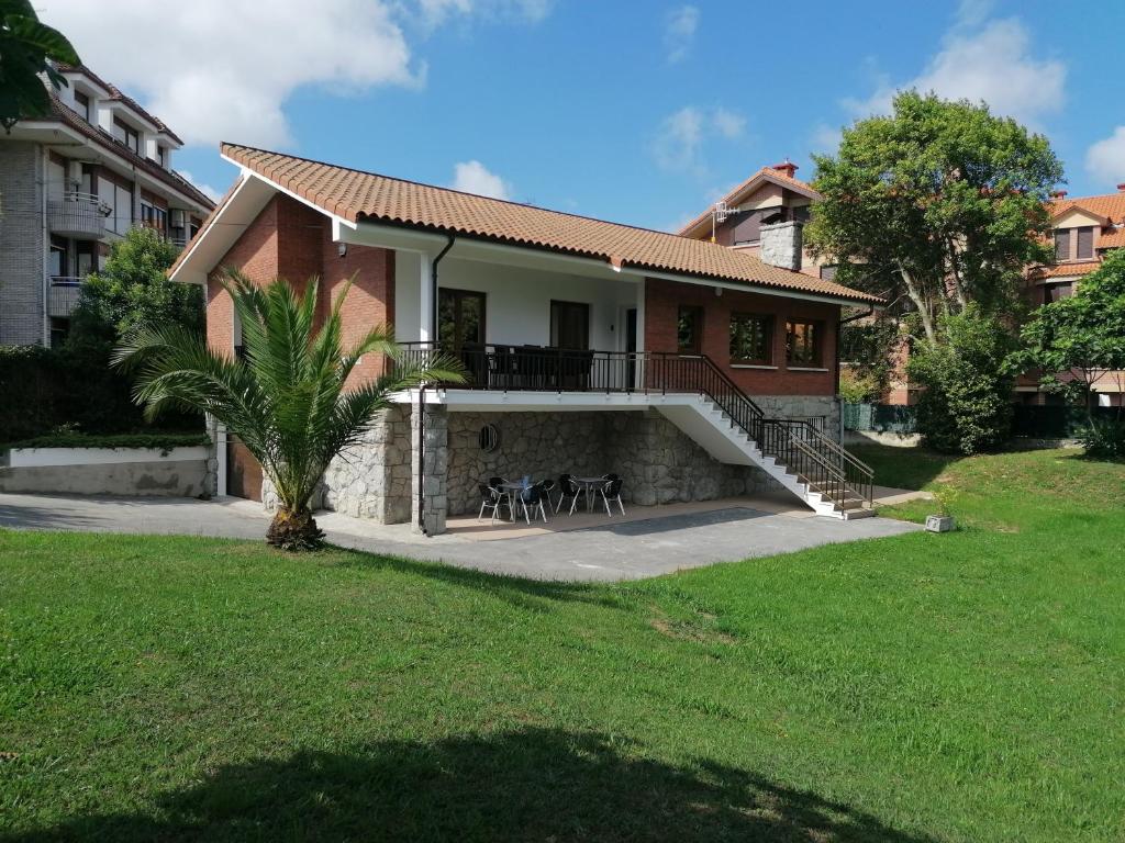 诺哈Villa El Encinar de Noja的带阳台和草坪的度假屋