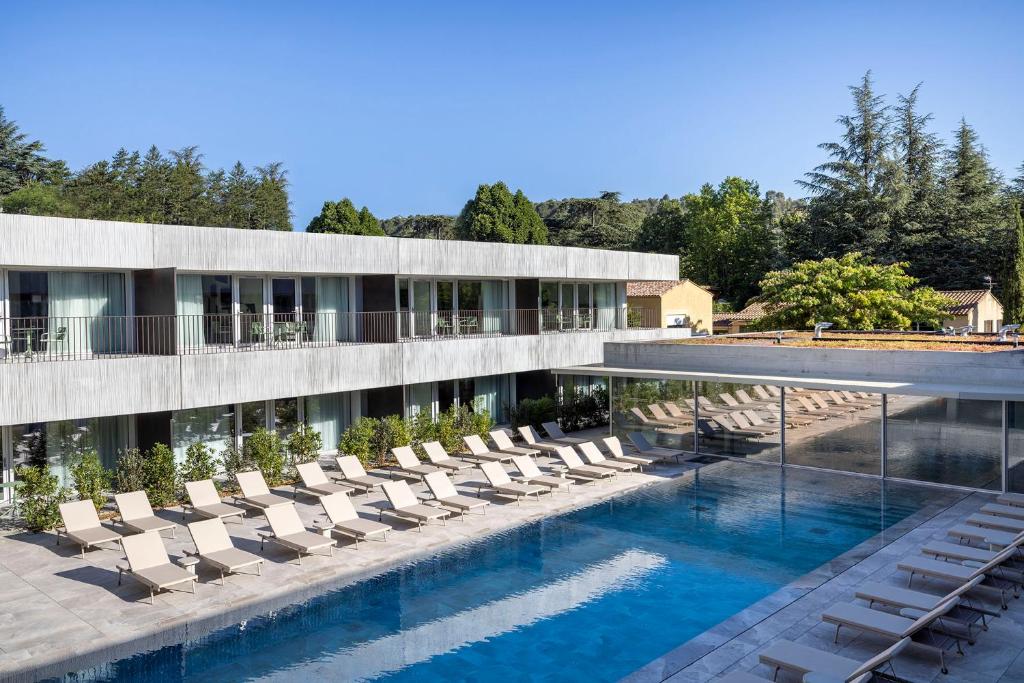 格雷乌莱班Villa Castellane的酒店配有躺椅和游泳池