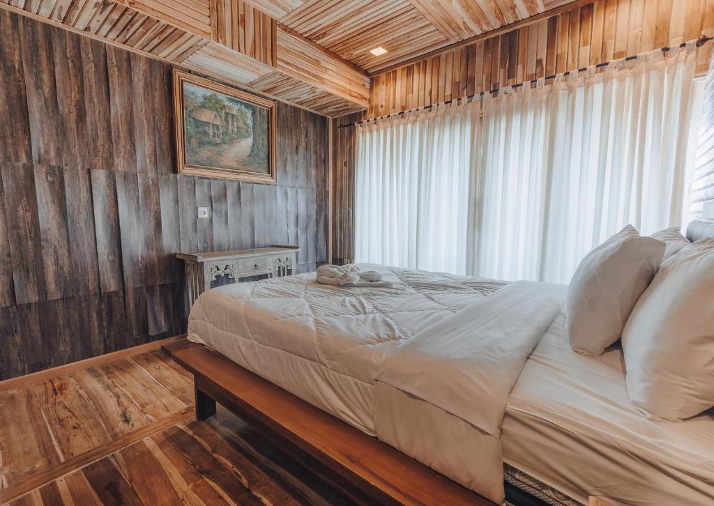 姆杜克Munduk Panorama的一间卧室配有一张木墙床