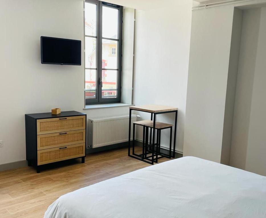 Moulins-EngilbertLE BON LABOUREUR的一间卧室配有一张床、一张书桌和一台电视。