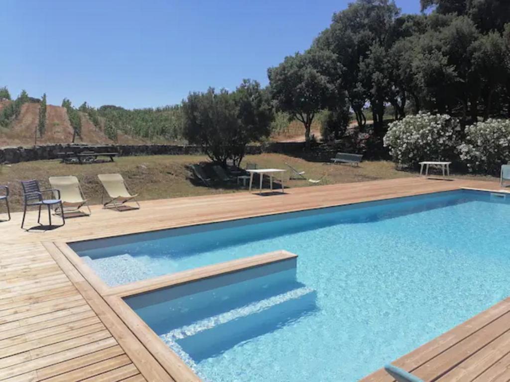 CarbucciaGîtes Carbuccia en Corse avec piscine chauffée的庭院旁设有木制甲板的大型游泳池