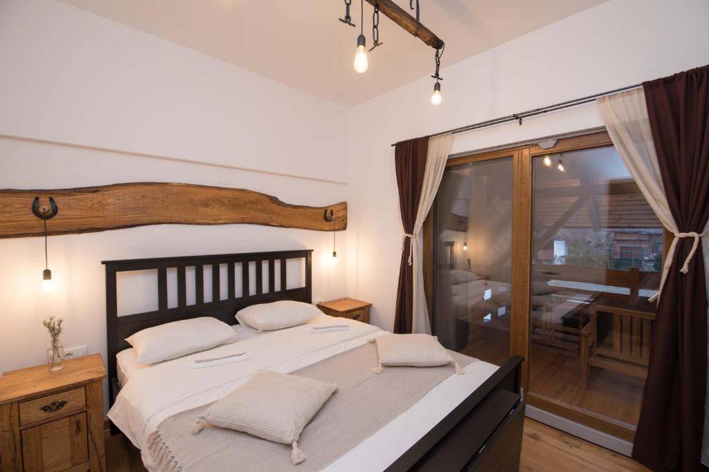 SOBE NA FARMI的一间卧室配有一张带白色床单的床和一扇窗户。